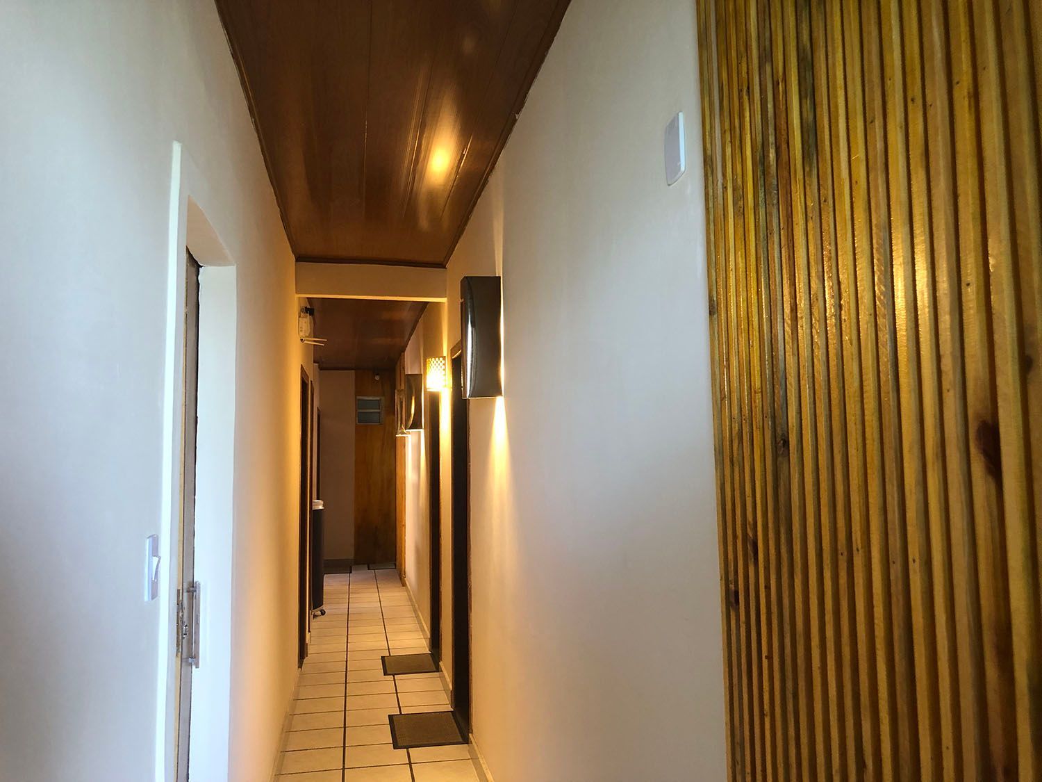 Um longo corredor com paredes de madeira e teto de madeira