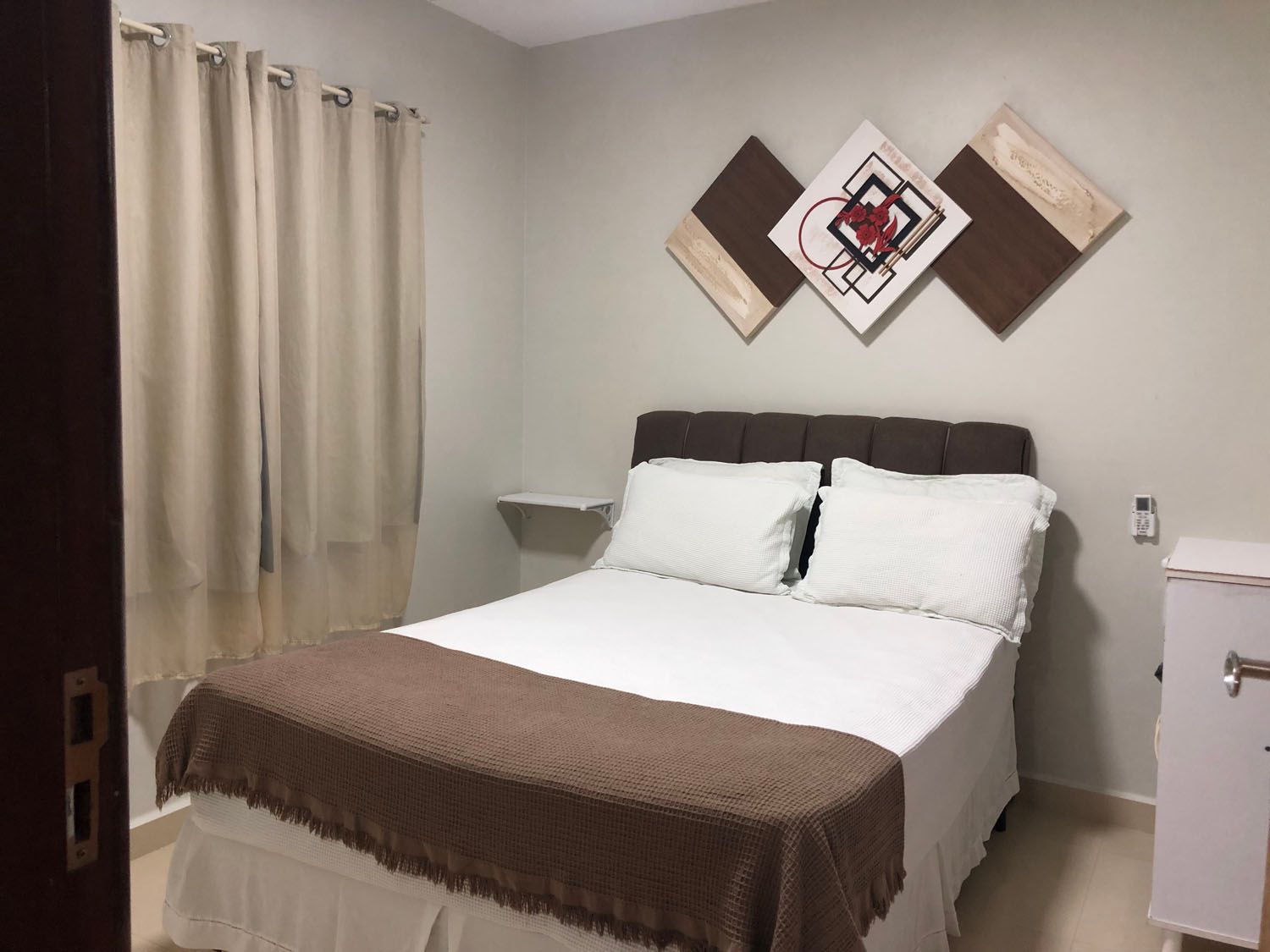 Um quarto com uma cama e uma pintura na parede