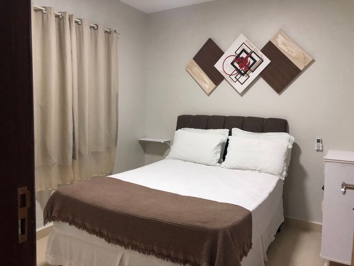 Um quarto com uma cama e uma pintura na parede