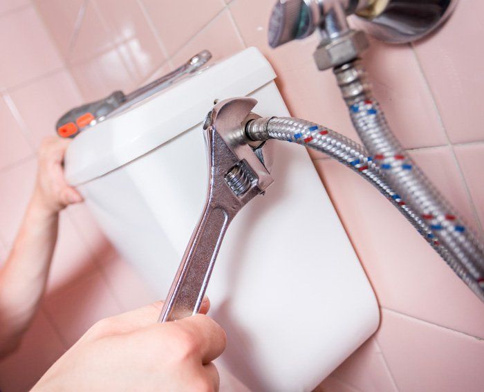 Plumber Fixing Toilet with Wrench — Northfield, NJ — Northfield Plumbing