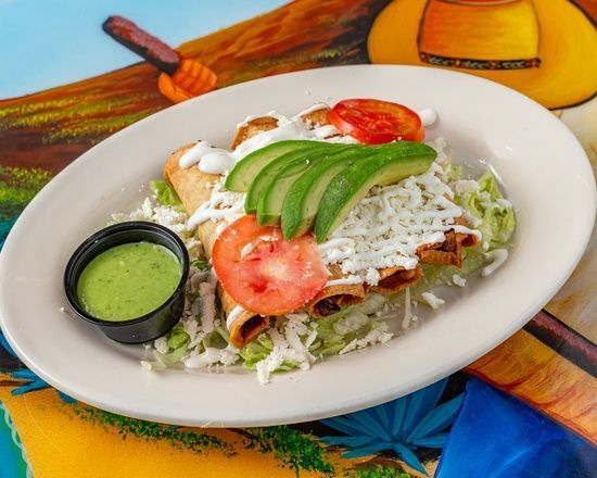 A plate of food with avocado , tomatoes and cheese on a table.