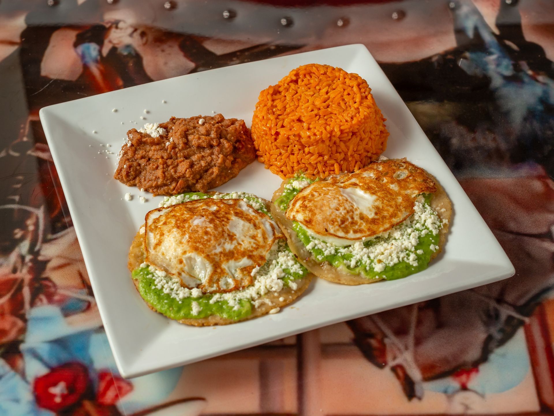 A white plate topped with rice , beans and pancakes.