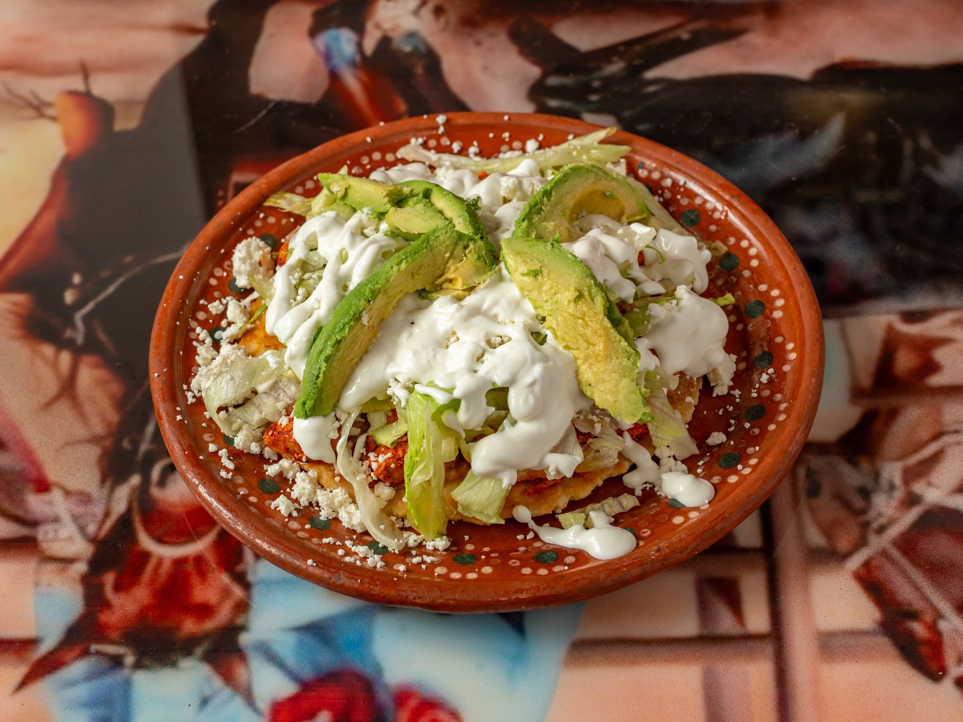 A plate of food with avocado and sour cream on a table.