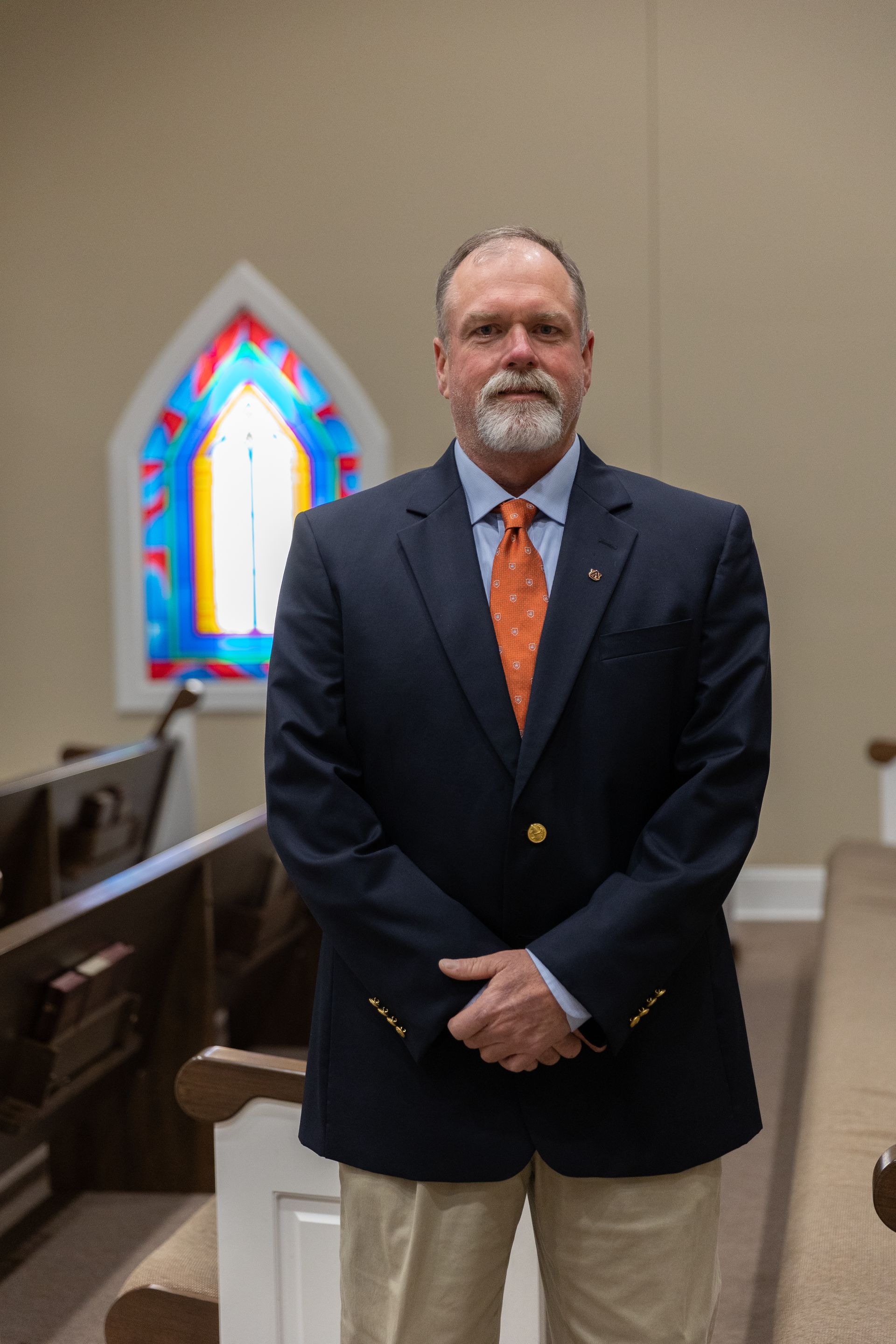 A man with a beard is wearing a plaid shirt and tie.