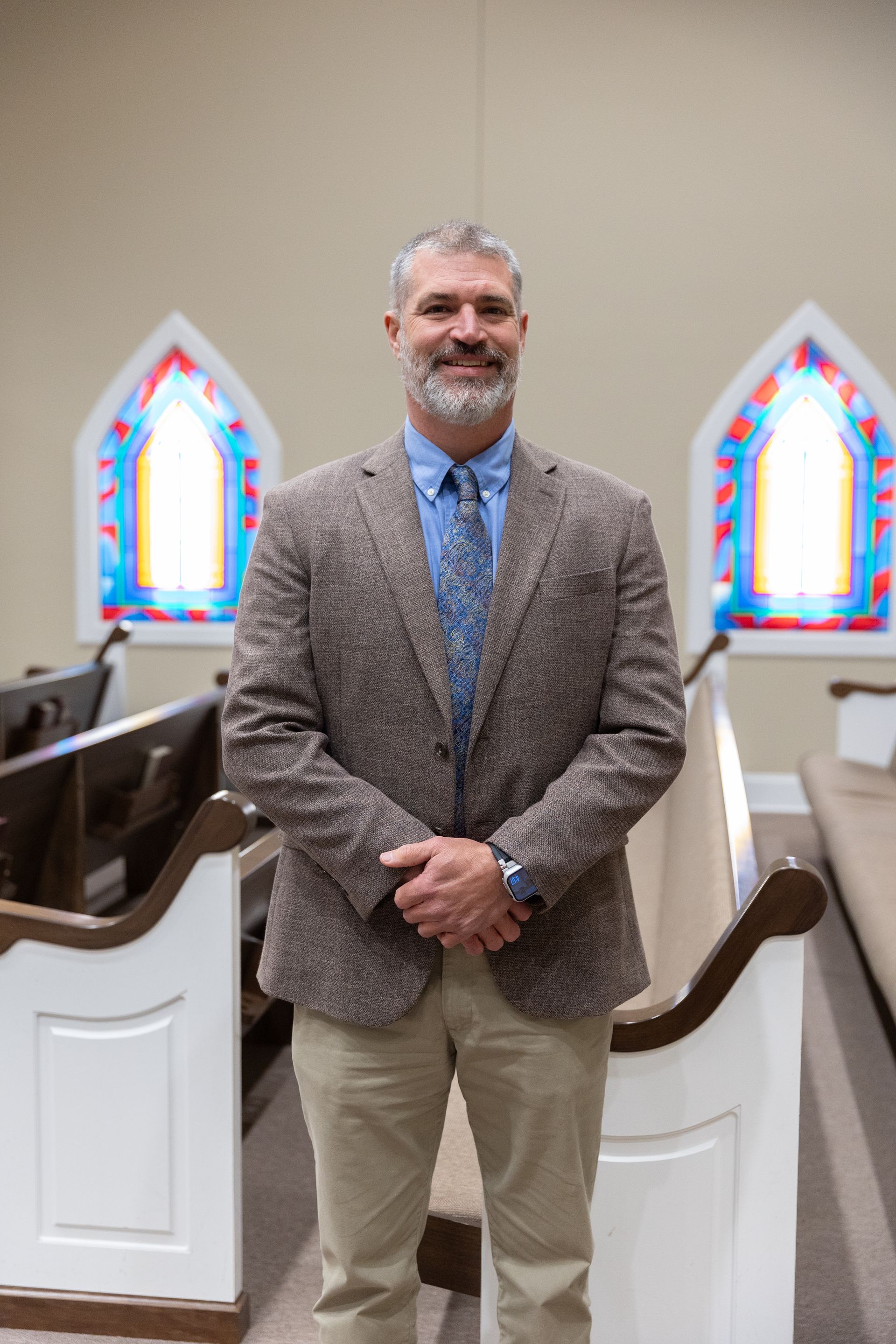 A man with a beard wearing a blue shirt and tie