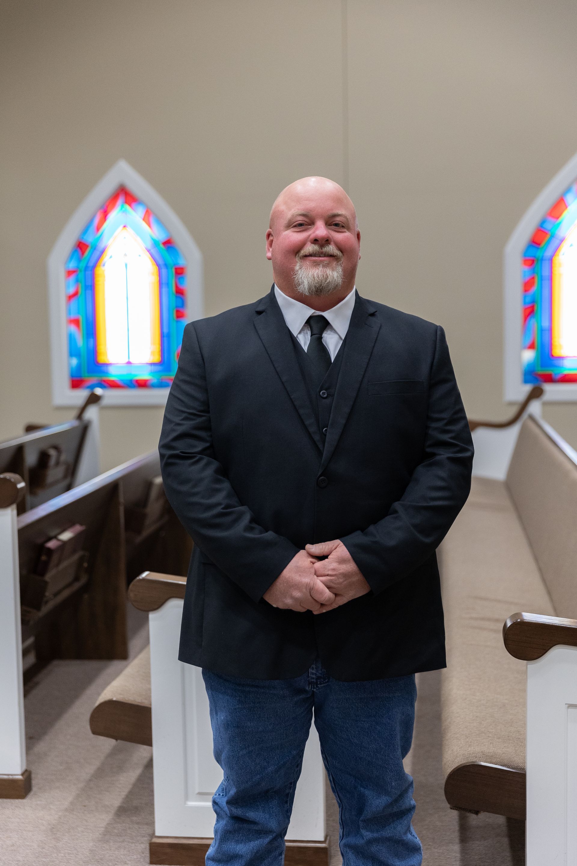 A man in a suit and tie is smiling for the camera