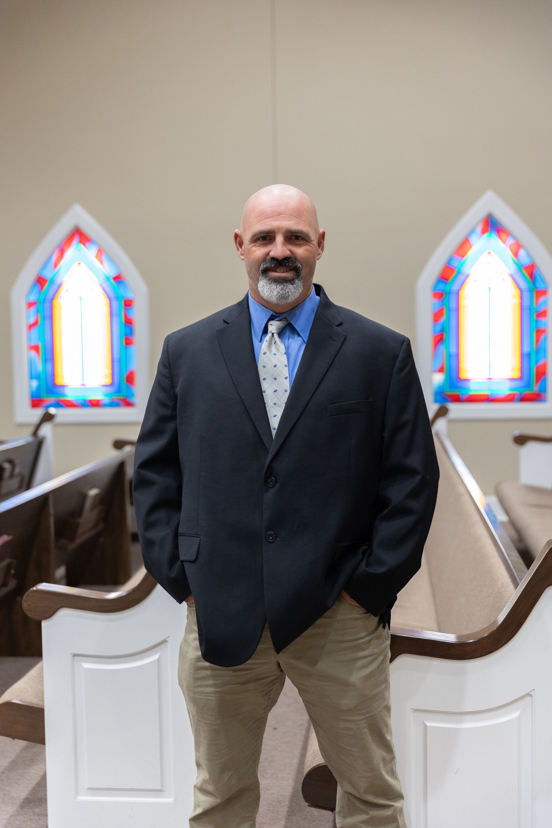 A man in a suit and tie is smiling for the camera