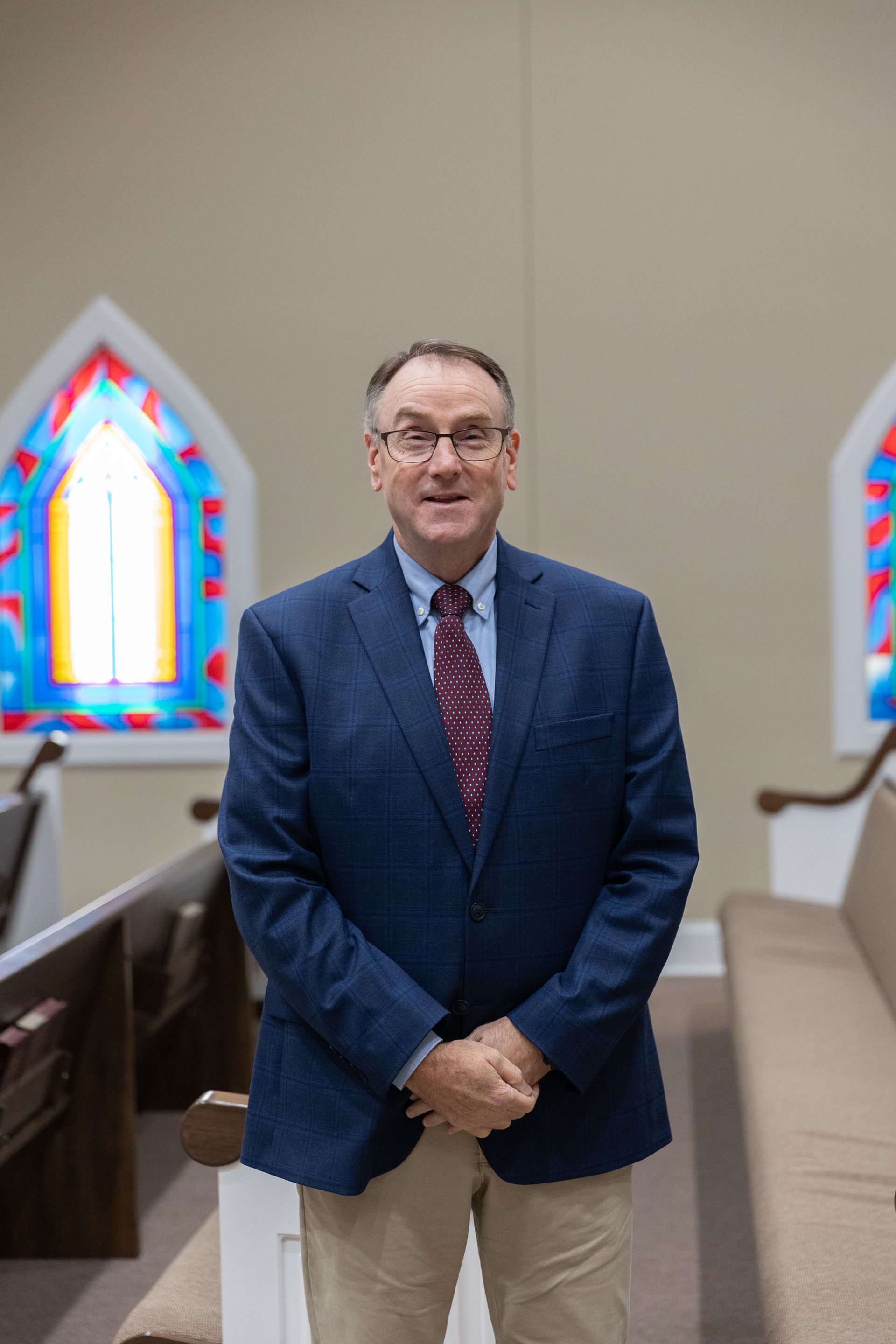 A man in a suit and tie is smiling for the camera