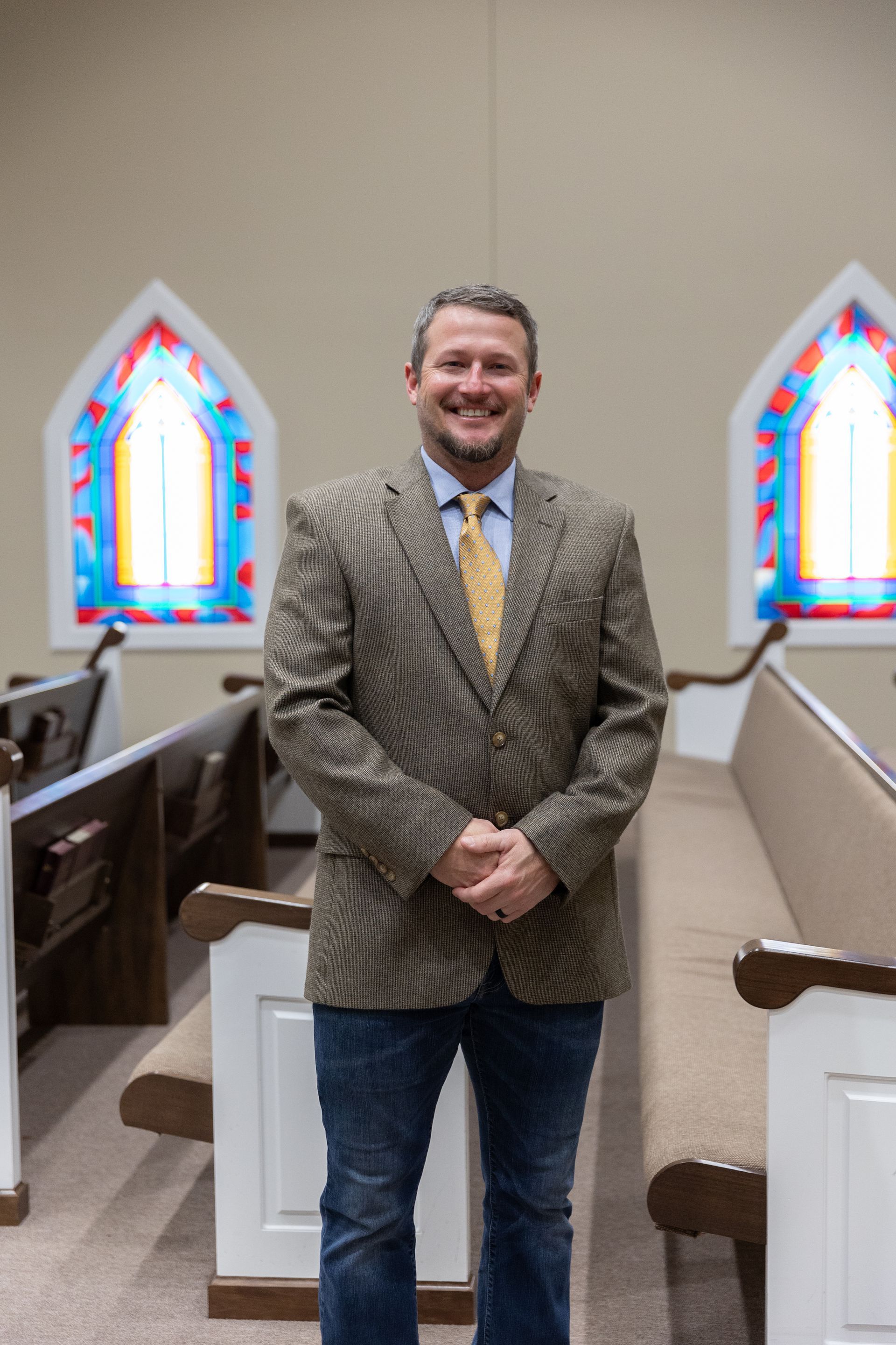 A bald man wearing glasses and a red tie