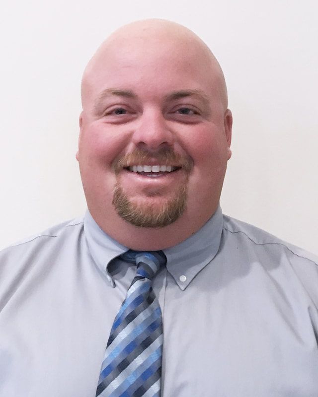 A man in a suit and tie is smiling for the camera