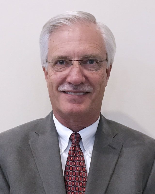 A man in a suit and tie is smiling for the camera.