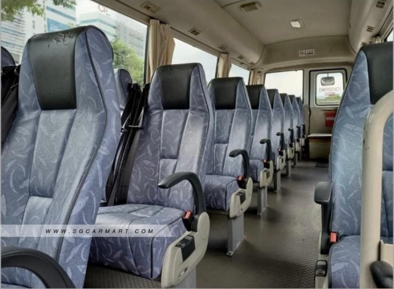 Interior of a bus with blue and black seats, side view.