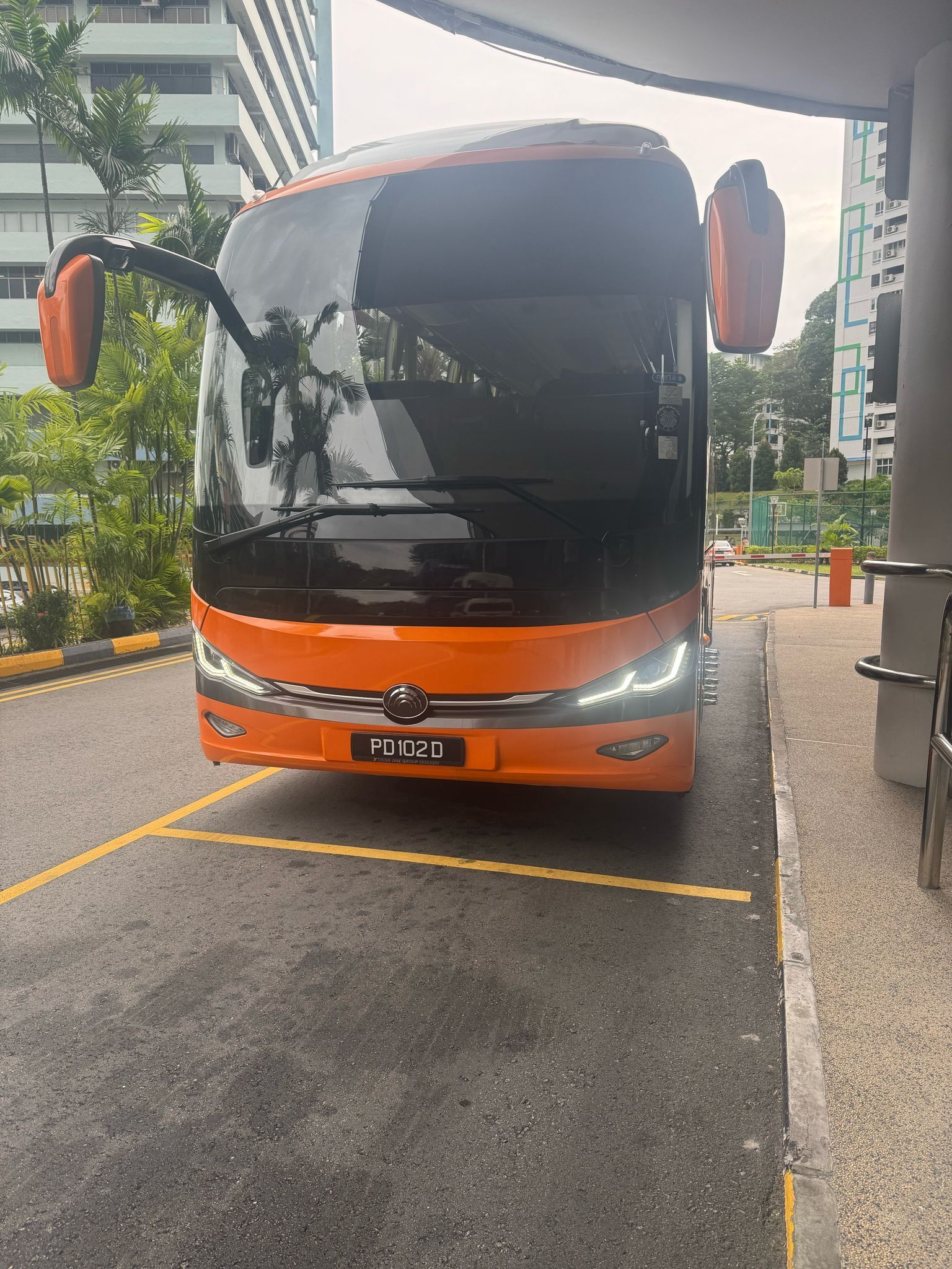 Orange bus parked, front view; Singapore.