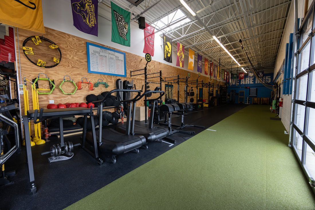 A gym with a lot of equipment and flags on the wall.