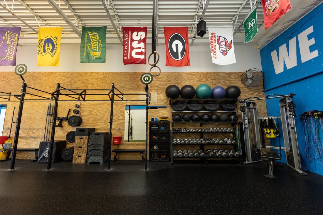 A gym with flags hanging from the ceiling and a sign that says `` welcome ''.