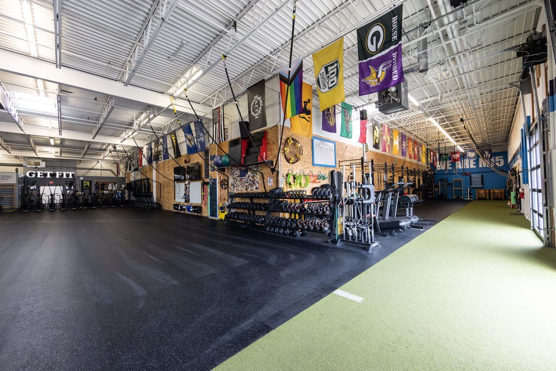 A large gym with a lot of flags hanging from the ceiling.