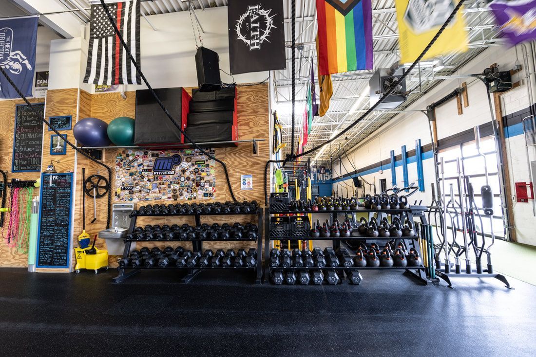 A gym filled with lots of dumbbells and flags.