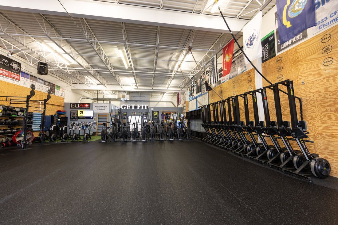 A gym with a lot of dumbbells on the floor.