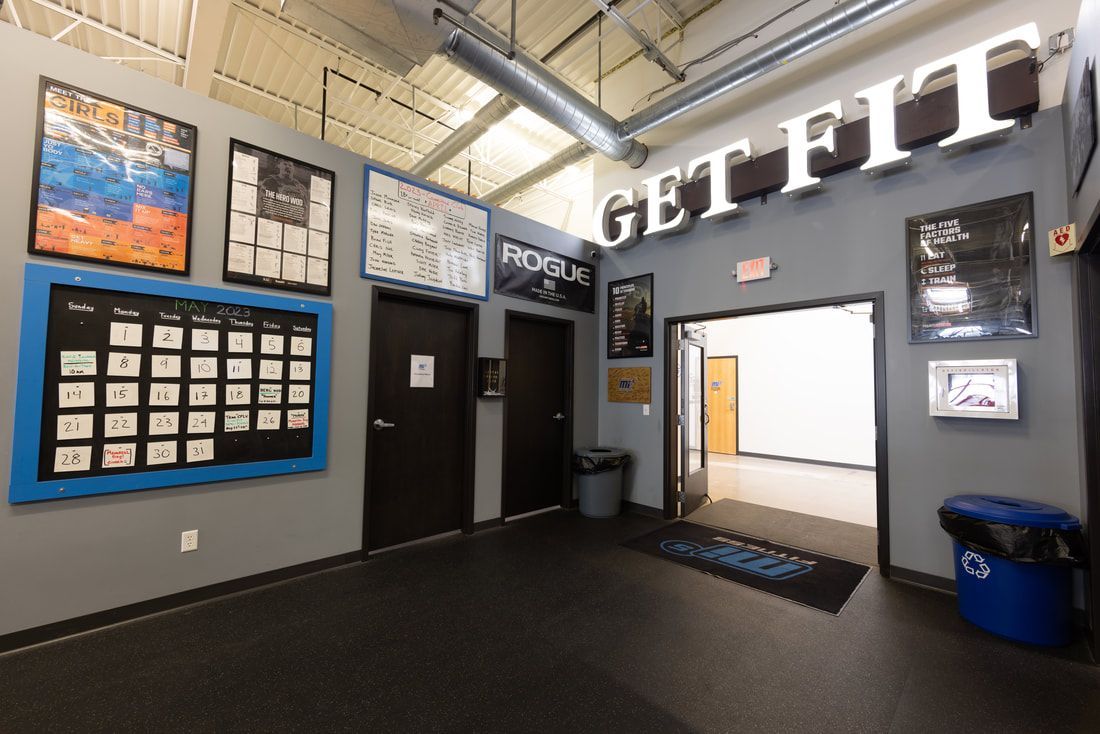 A gym with a sign that says get fit on the wall.