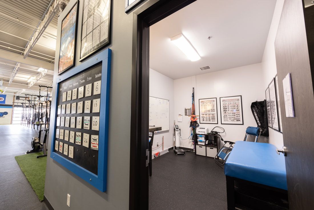A gym with a blue table and a chalkboard on the wall.