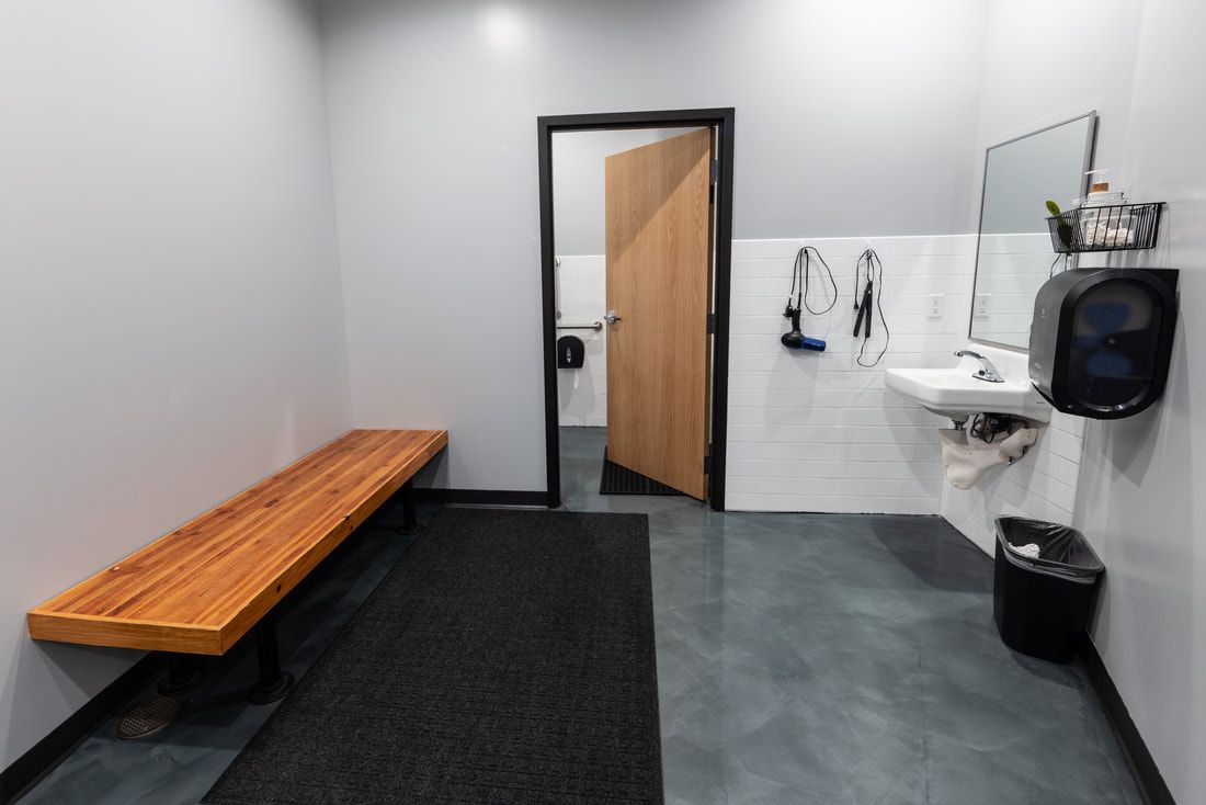 A locker room with a wooden bench and a sink.