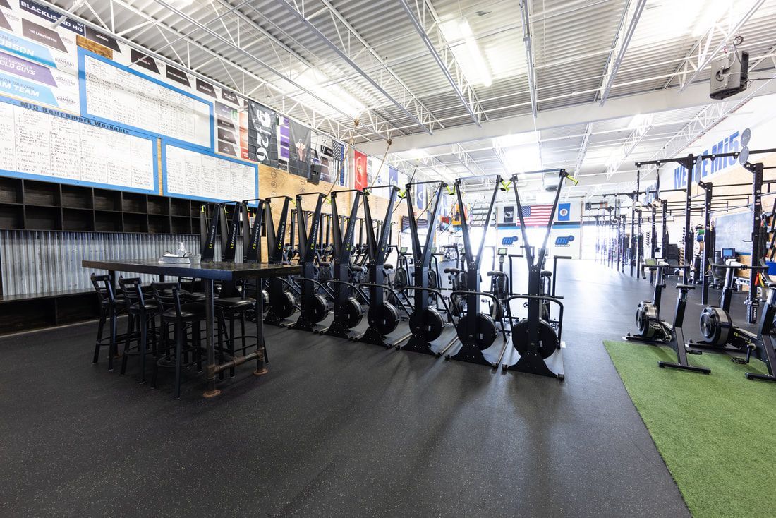 A gym filled with lots of exercise equipment and tables.
