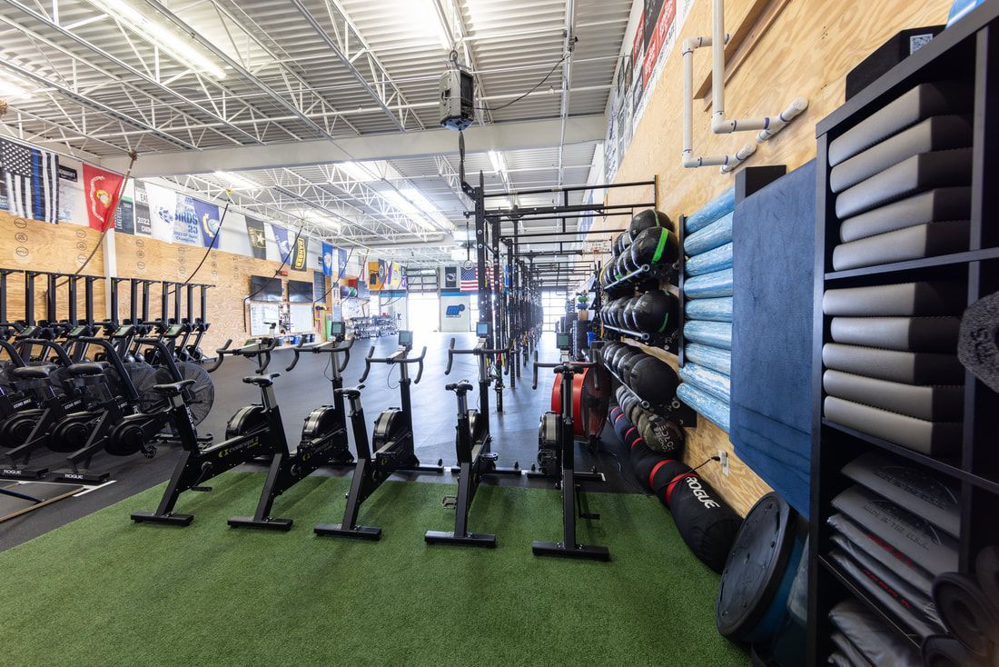 A gym filled with lots of exercise equipment and a row of exercise bikes.