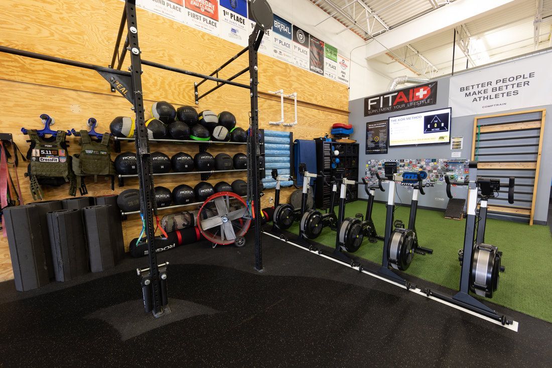 A gym filled with lots of exercise equipment , including a row of exercise bikes.