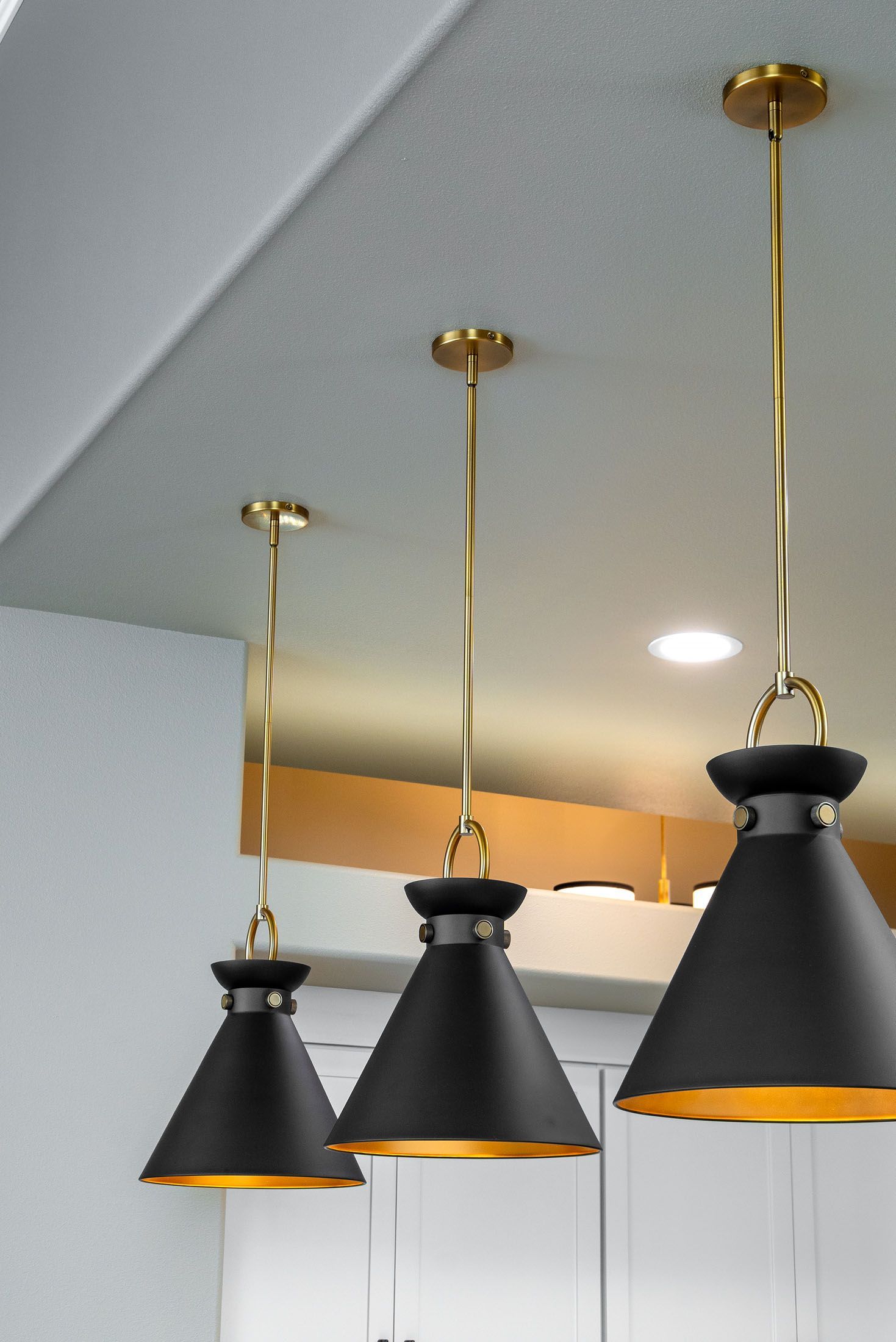 Three black and gold pendant lights are hanging from the ceiling