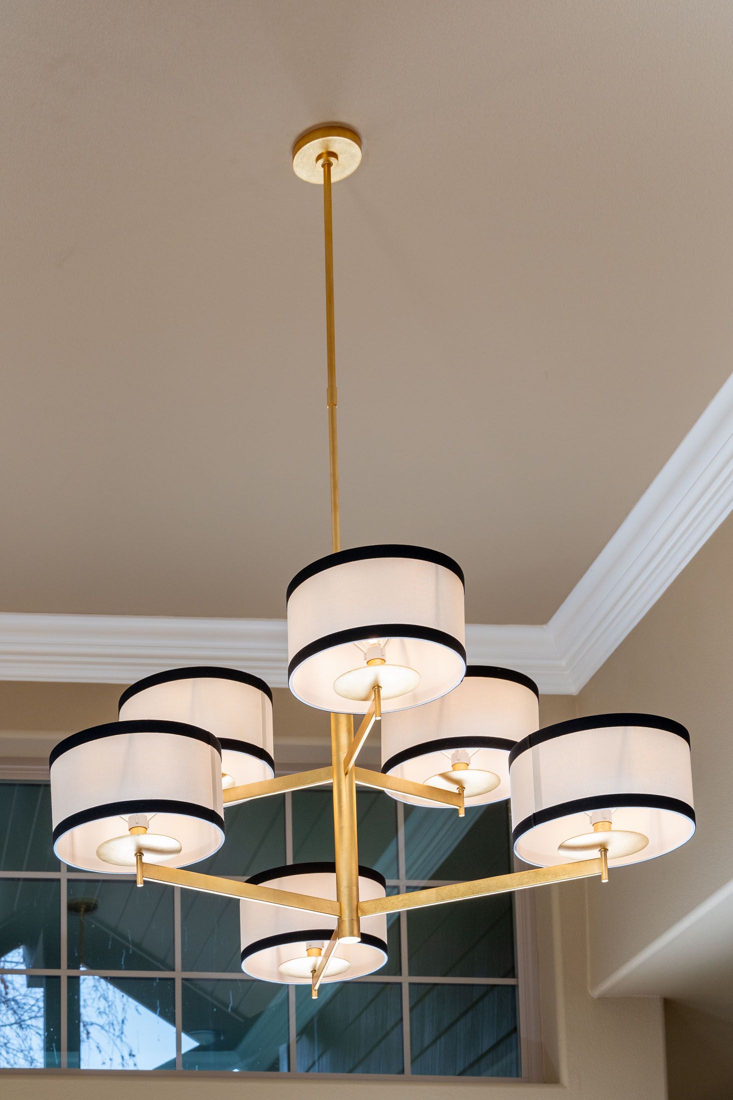 A chandelier with white and black shades is hanging from the ceiling