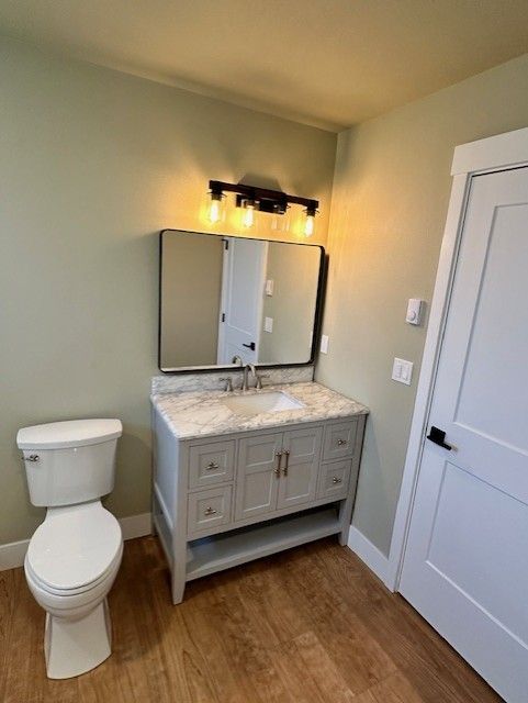A bathroom with a toilet a sink and a mirror