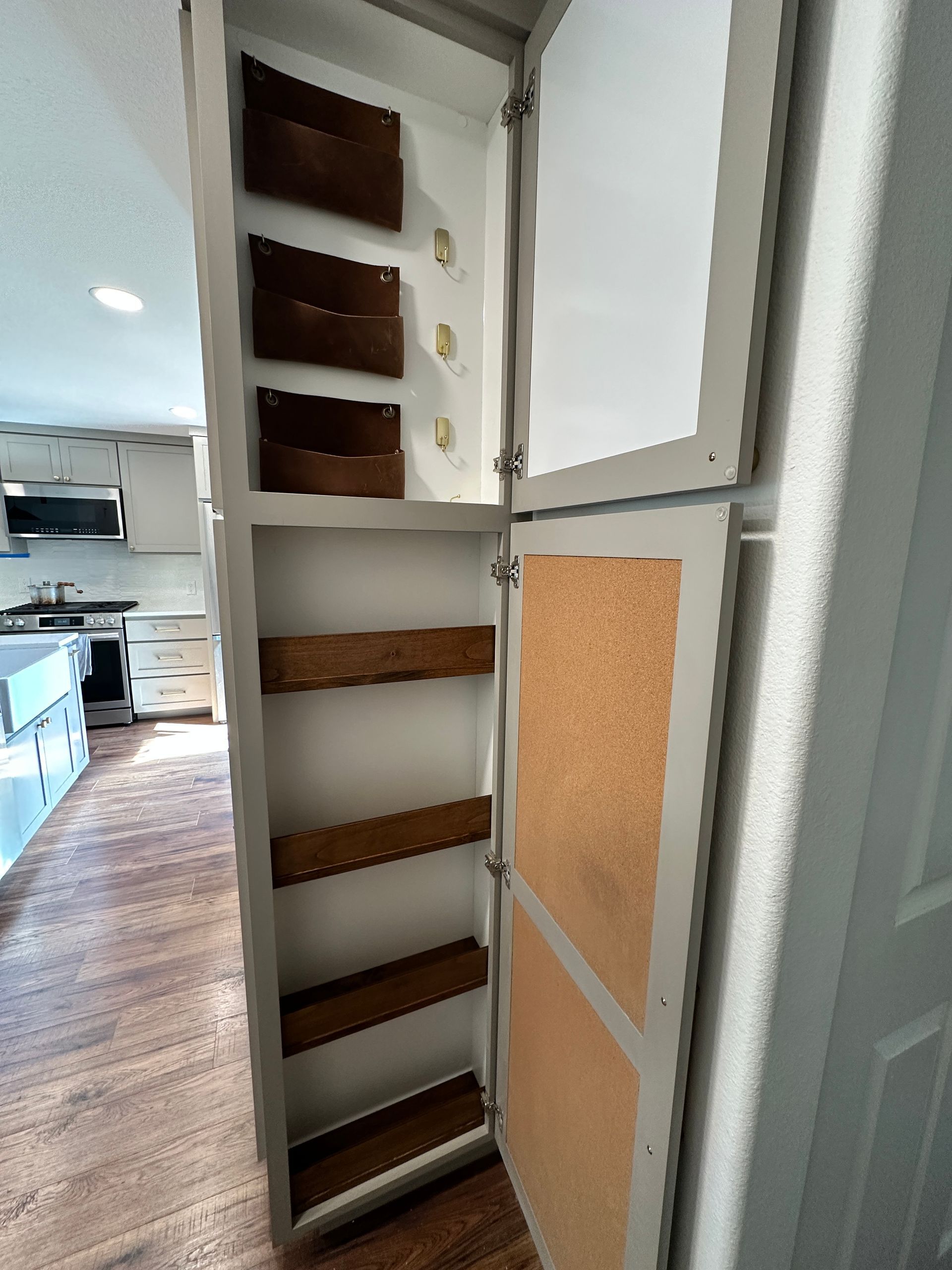 A kitchen cabinet with the door open and shelves.