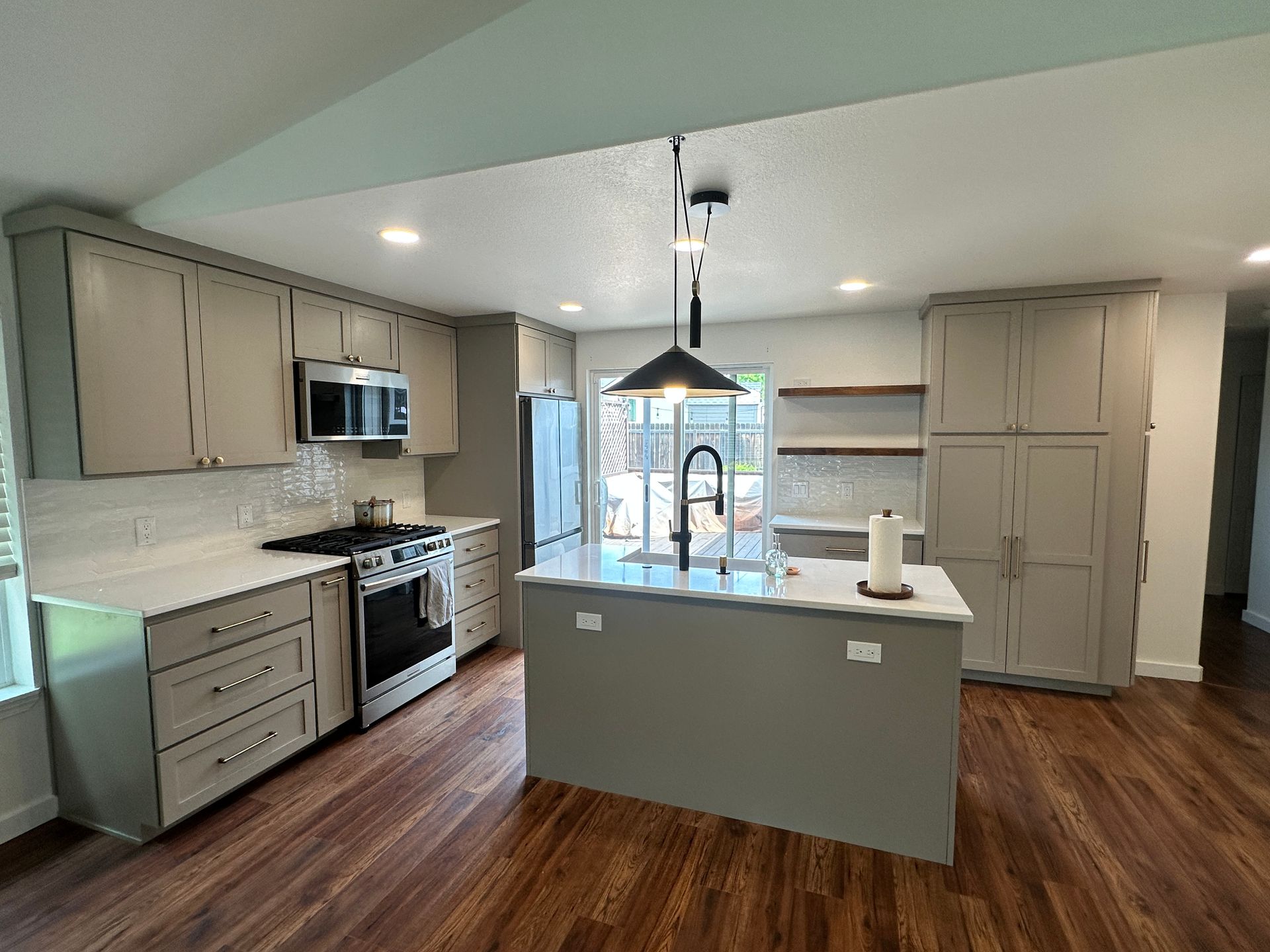 A kitchen with a large island and stainless steel appliances.
