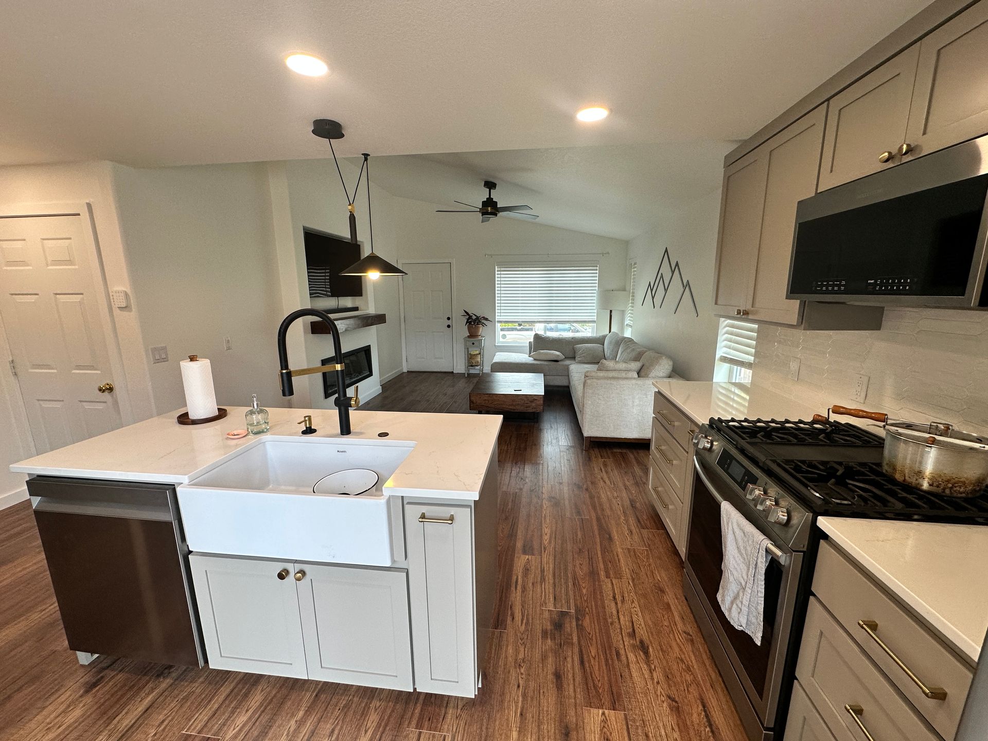 A kitchen with a sink , stove , and dishwasher.