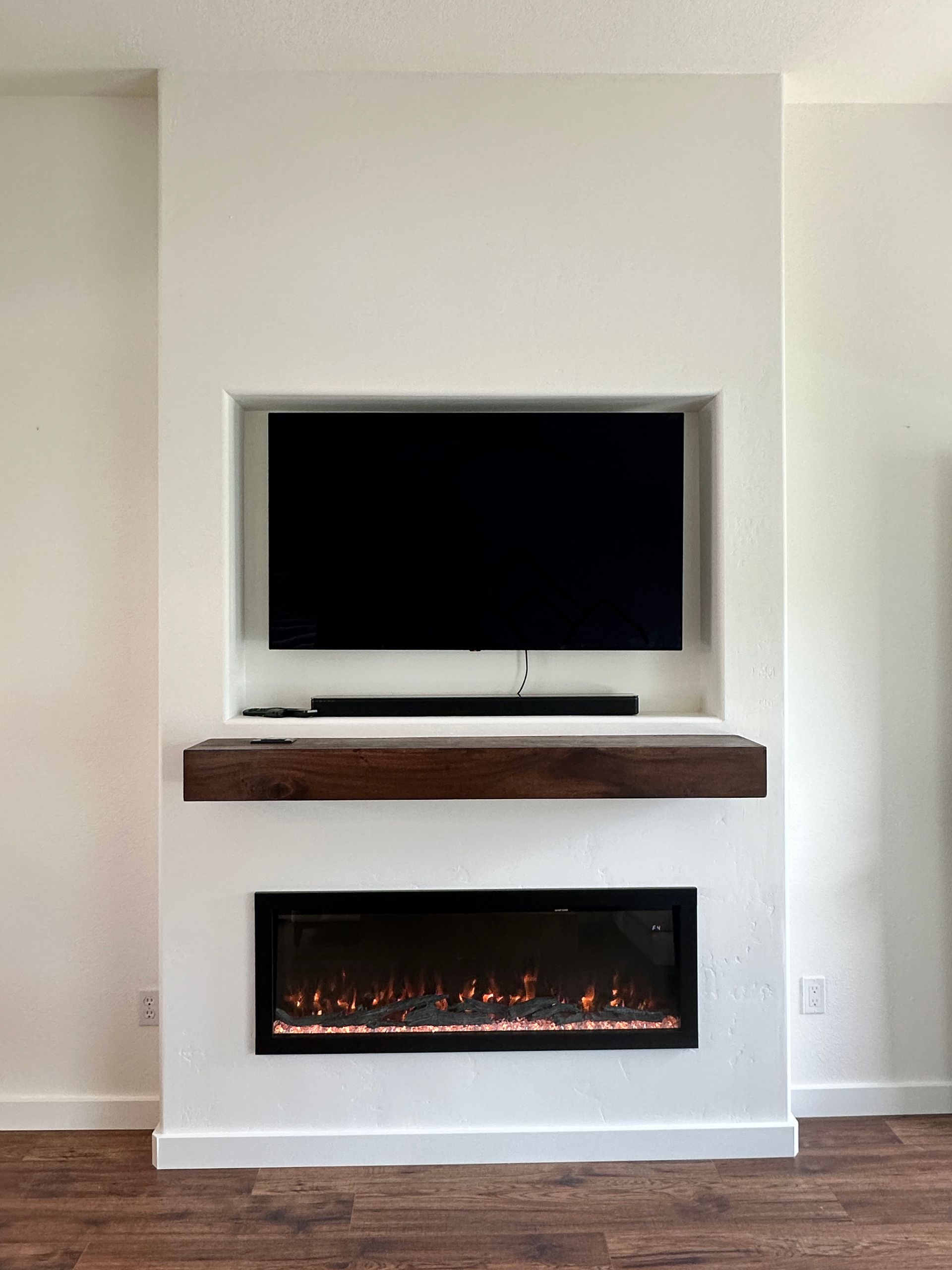 A living room with a fireplace and a flat screen tv mounted on the wall.