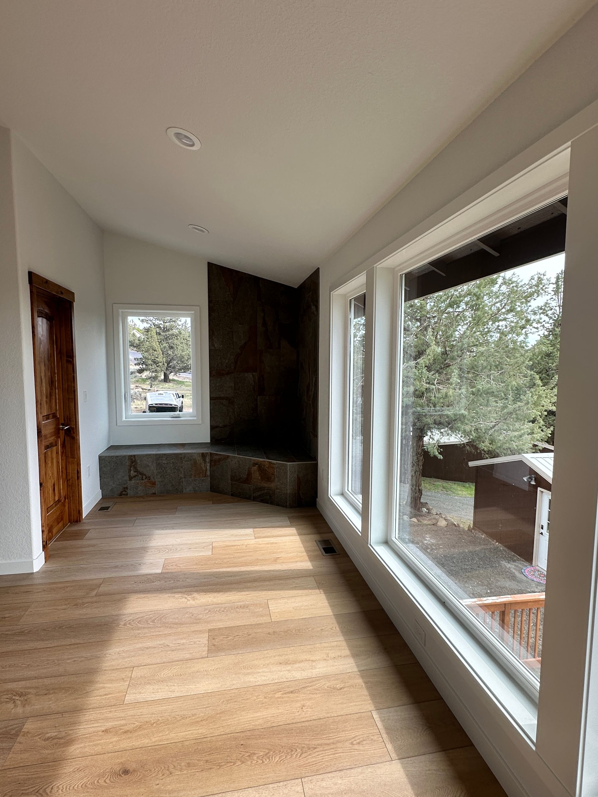 An empty room with a lot of windows and wooden floors.