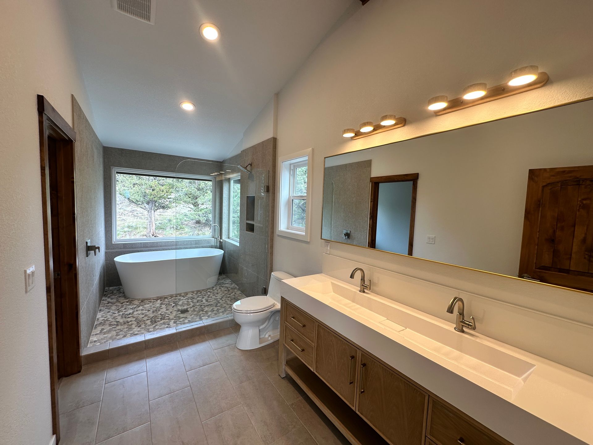 A bathroom with a tub , toilet , sink and mirror.