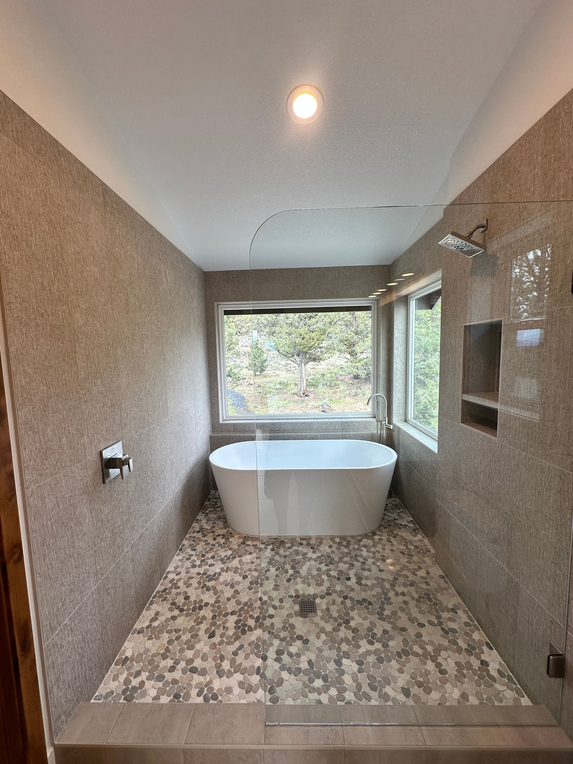 A bathroom with a bathtub and a window.