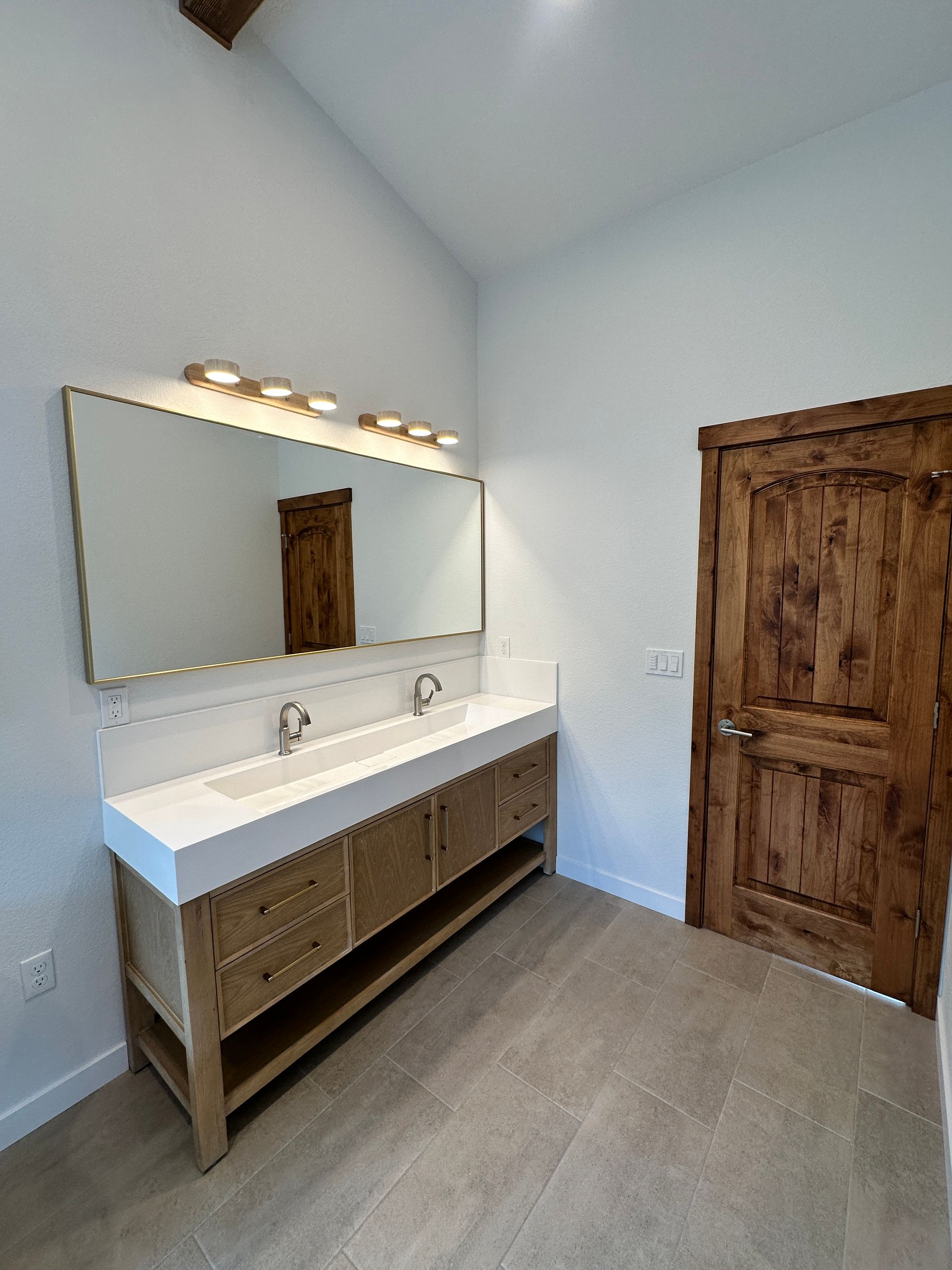 A bathroom with two sinks and a large mirror.