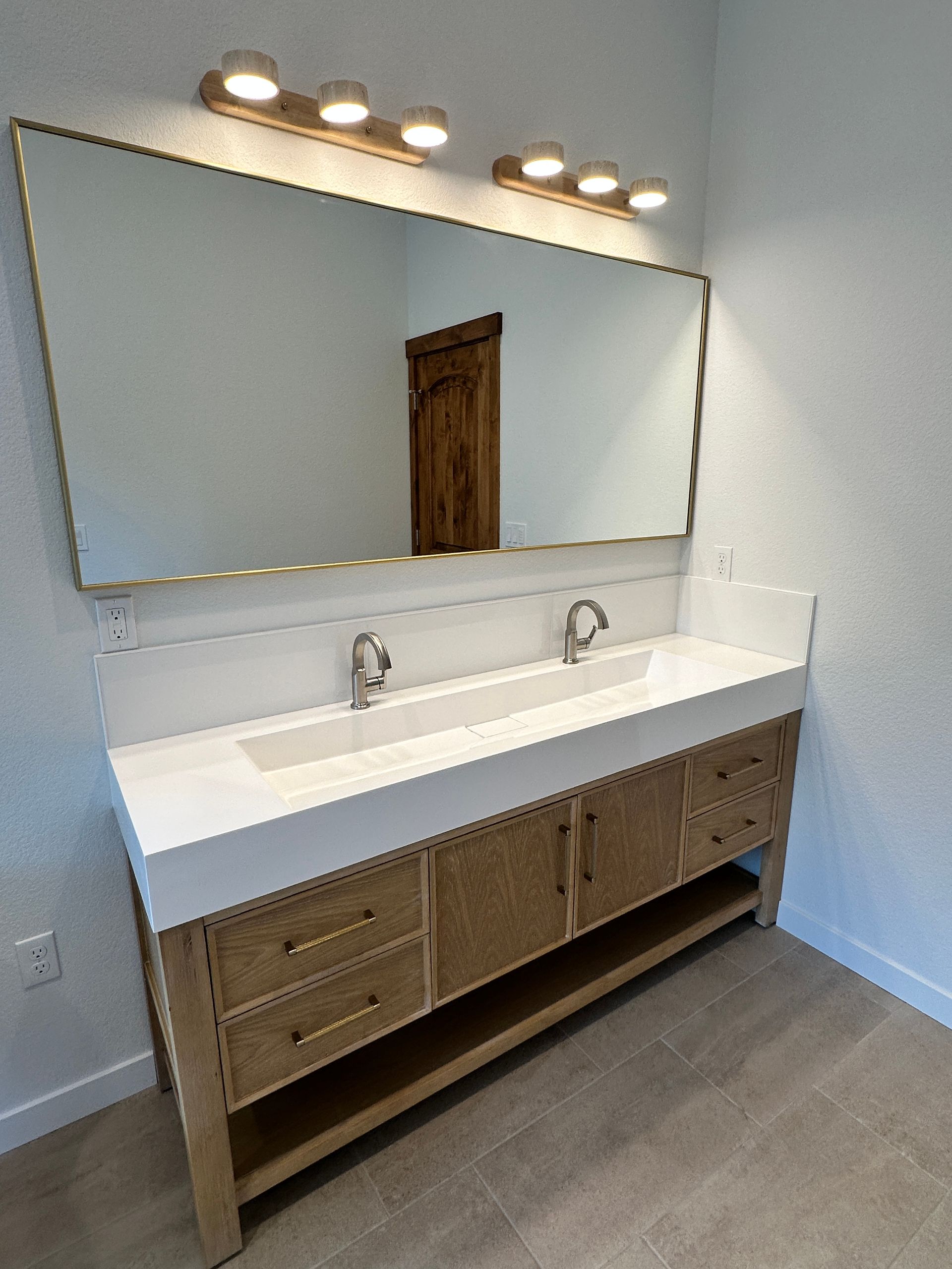 A bathroom with two sinks and a large mirror.