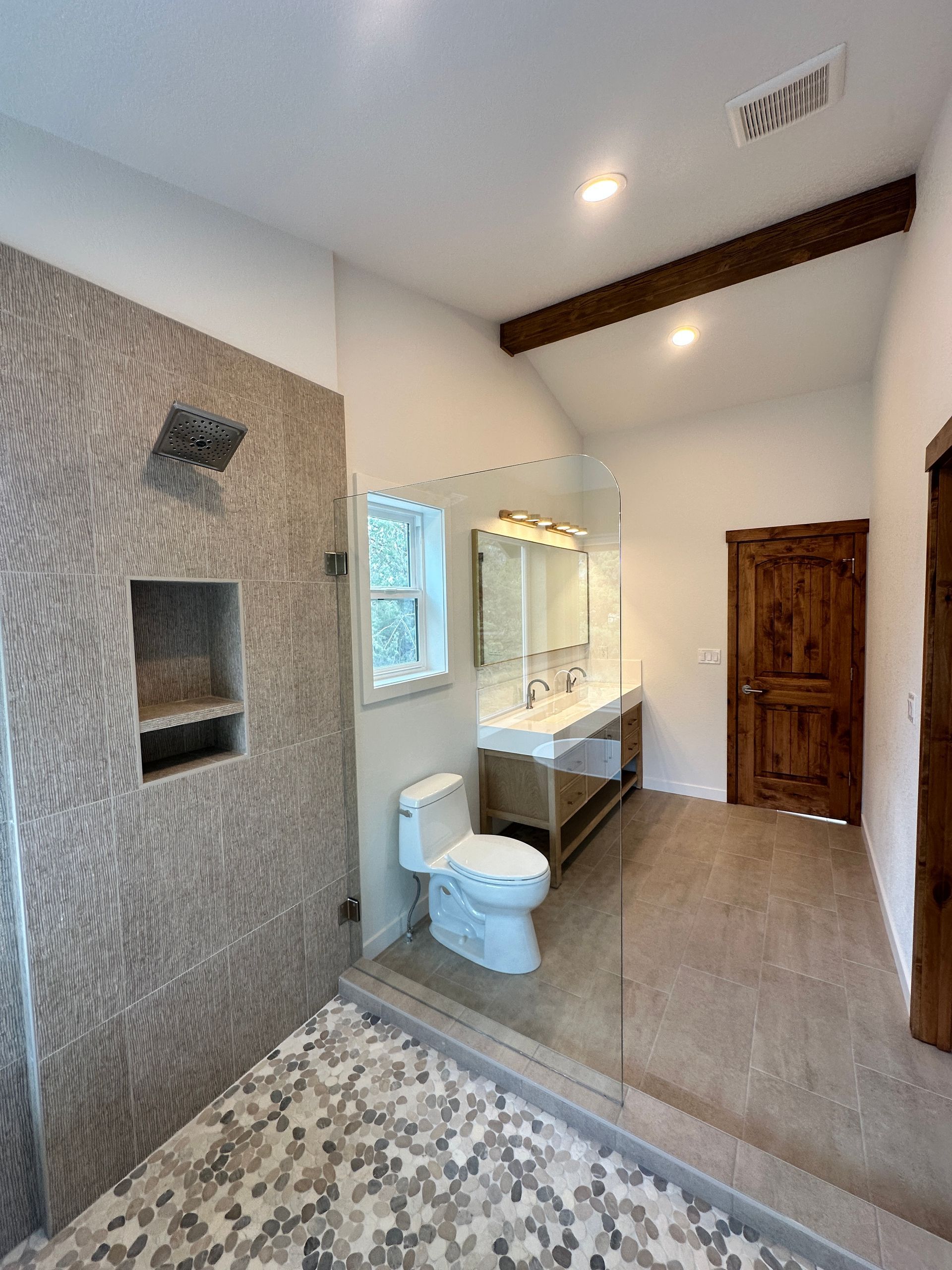 A bathroom with a toilet , sink and shower.