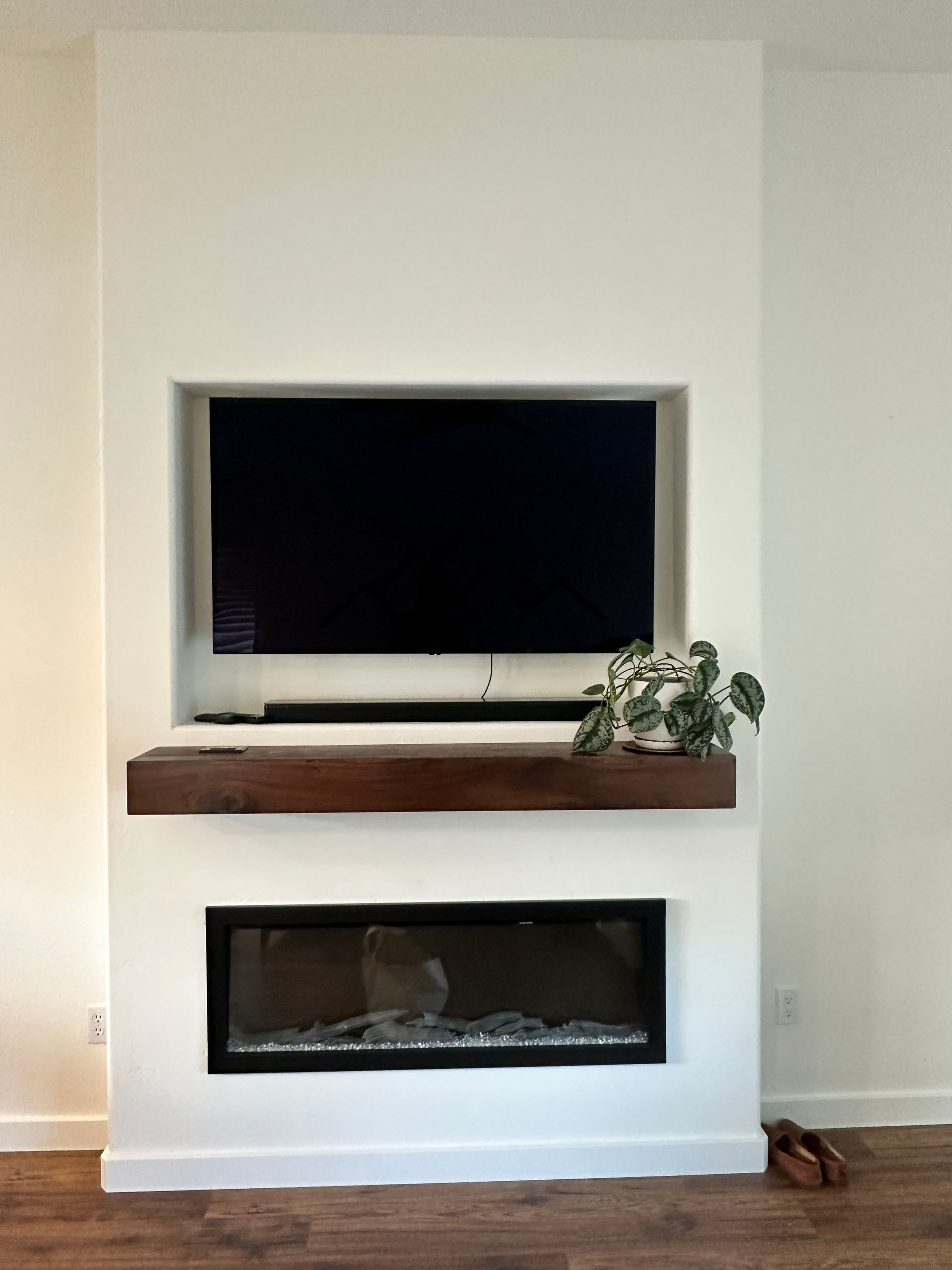 A living room with a fireplace and a flat screen tv mounted on the wall.