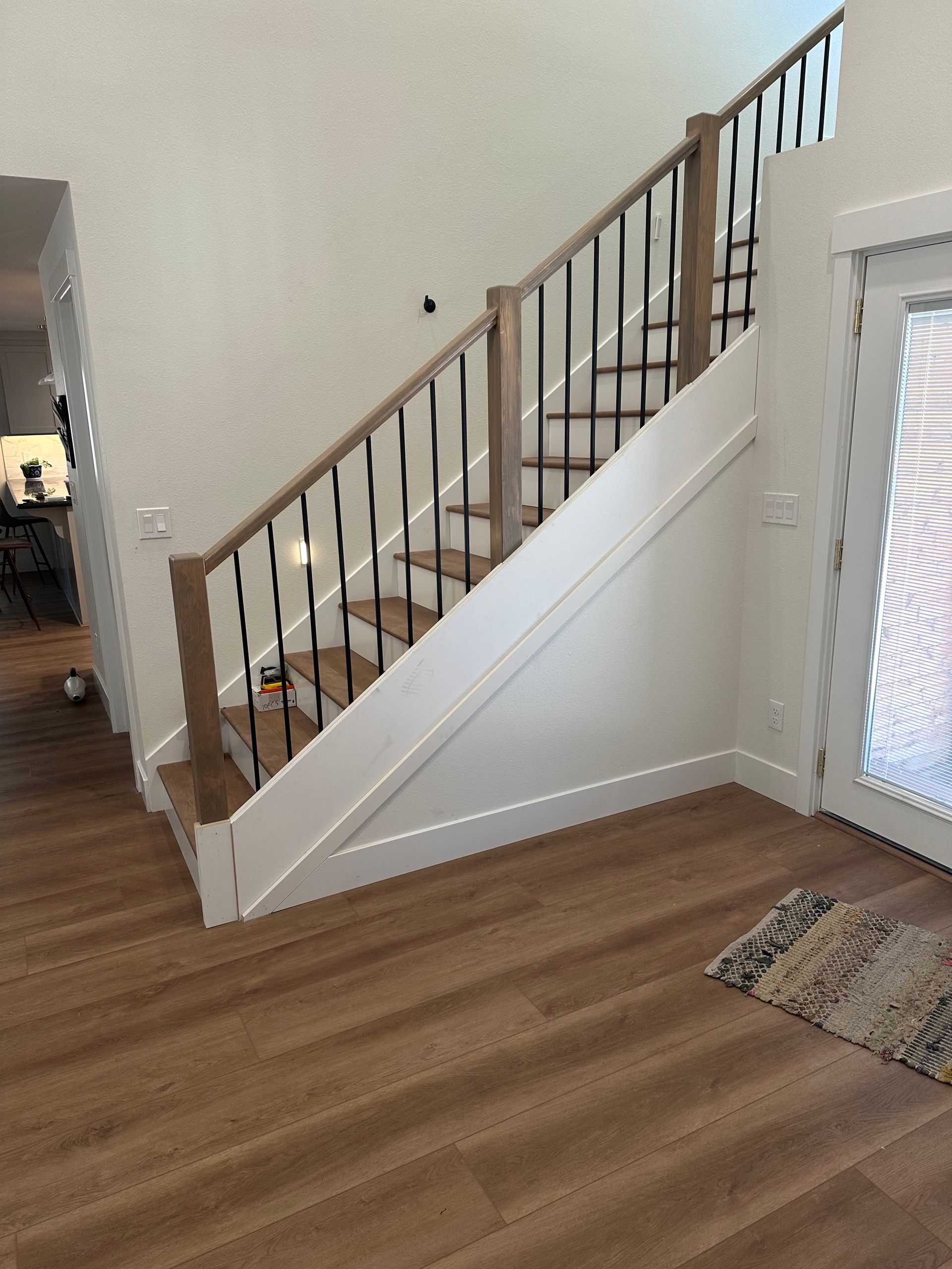 A wooden staircase with a wrought iron railing in a house
