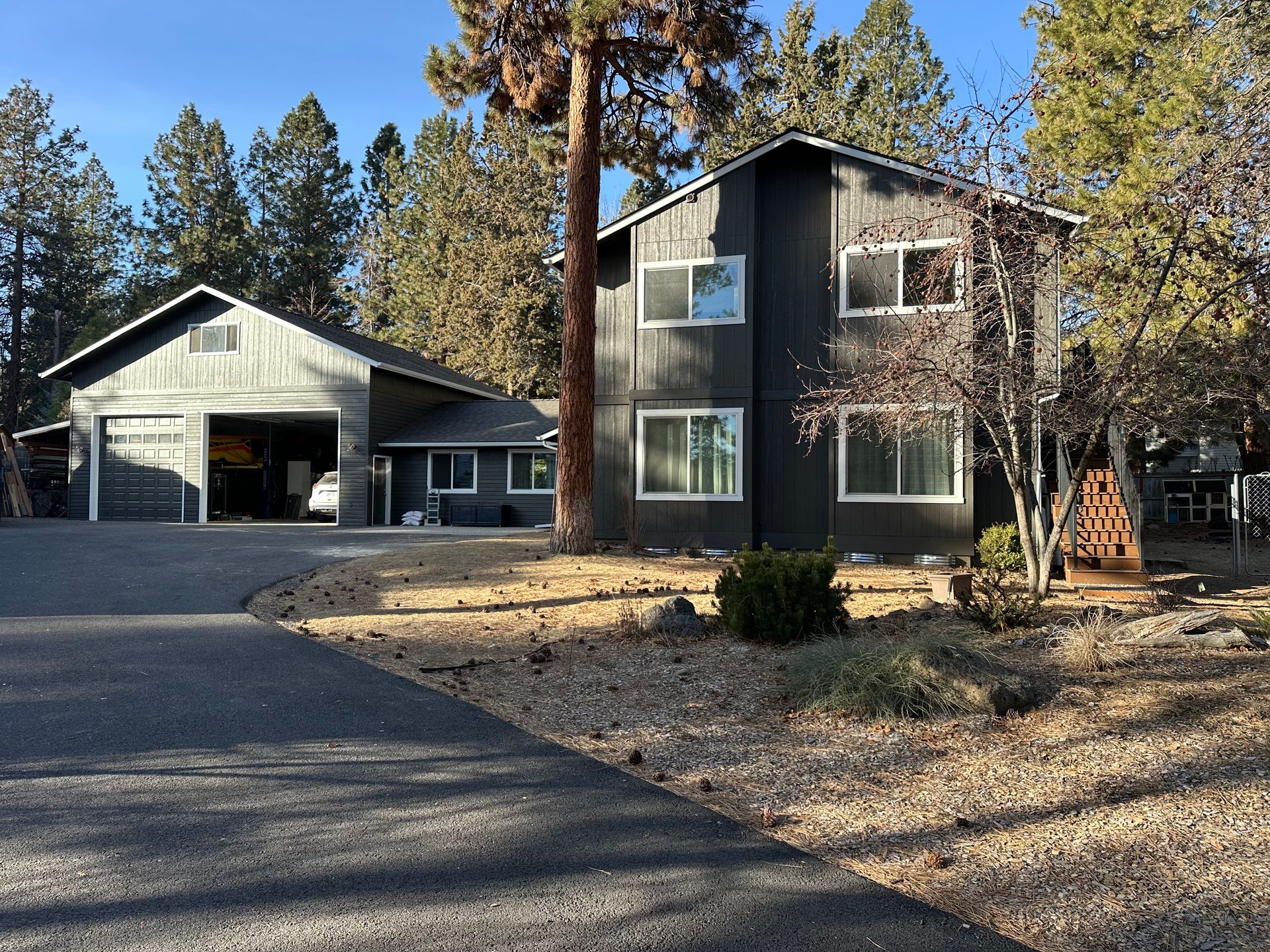 A large house with a garage and trees in the background