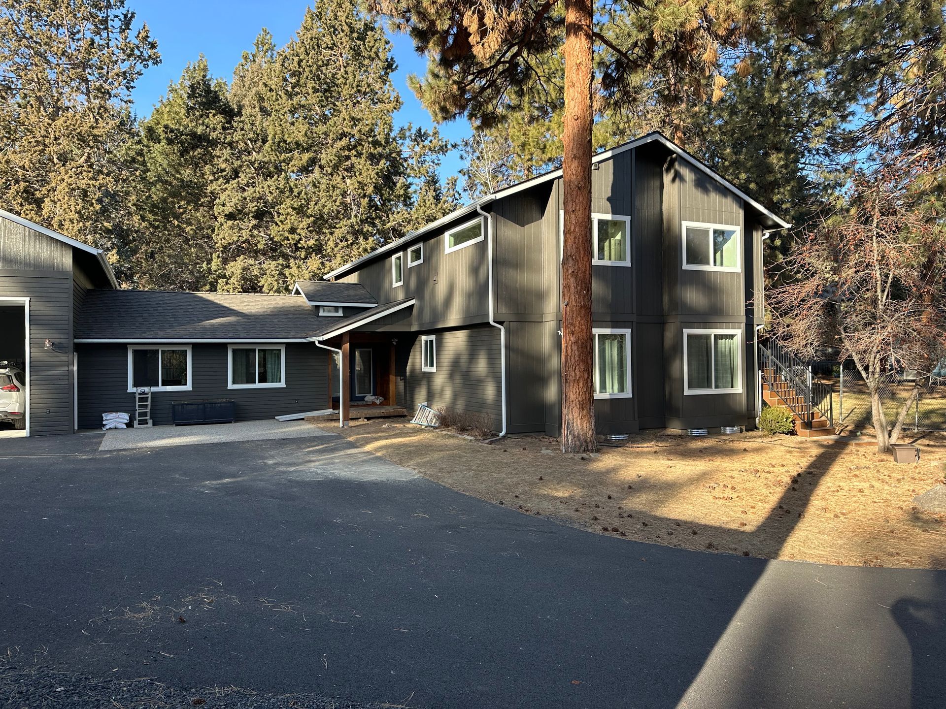 A large house with a lot of windows is surrounded by trees