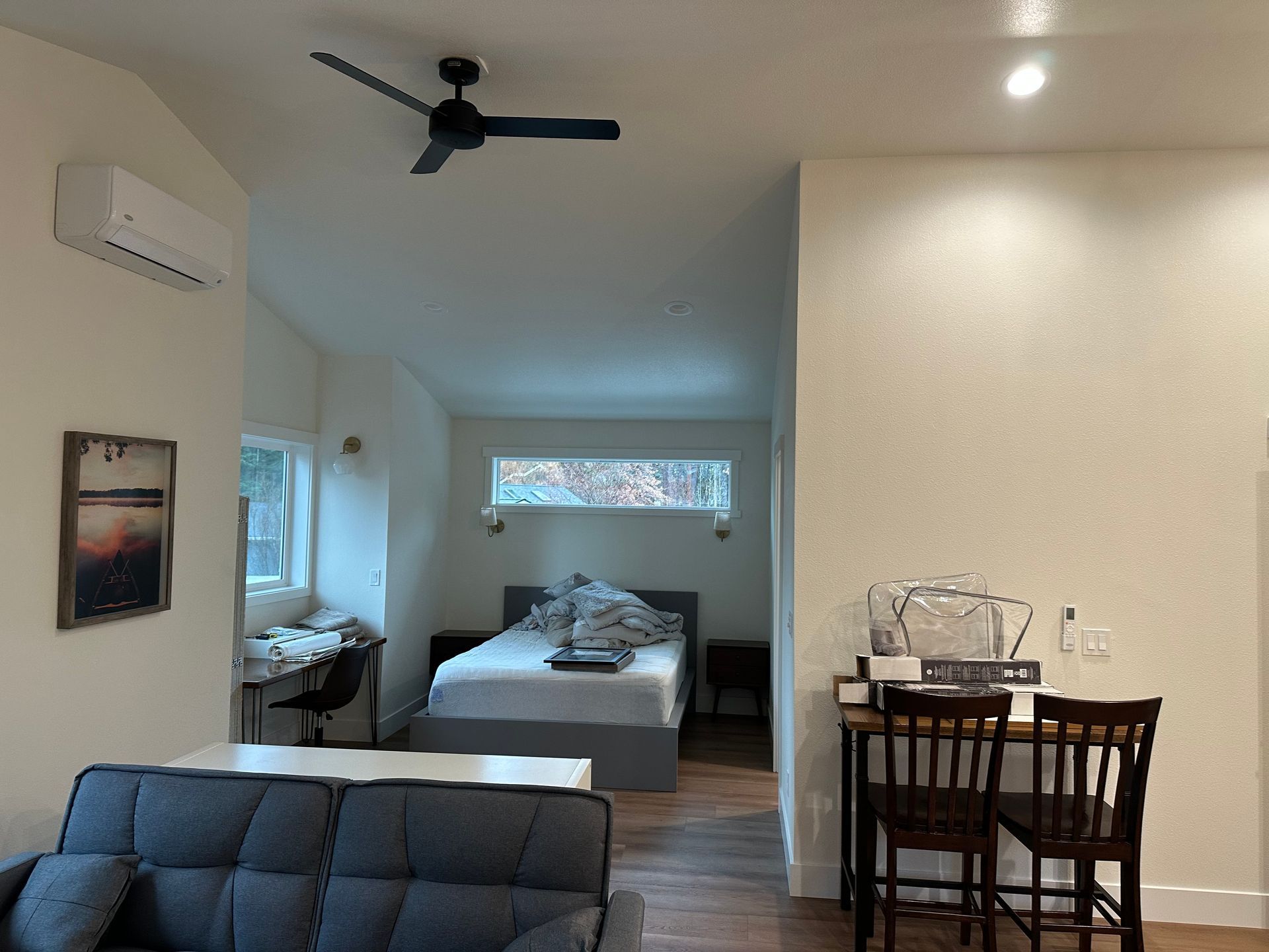 A bedroom with a ceiling fan and a couch