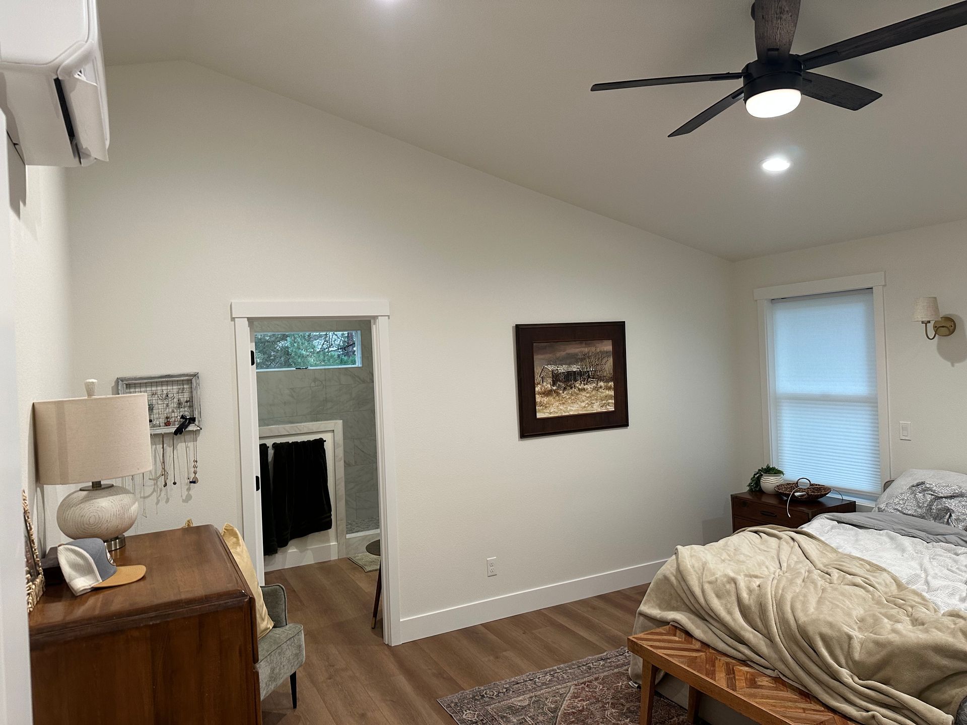 A bedroom with a bed and a ceiling fan.