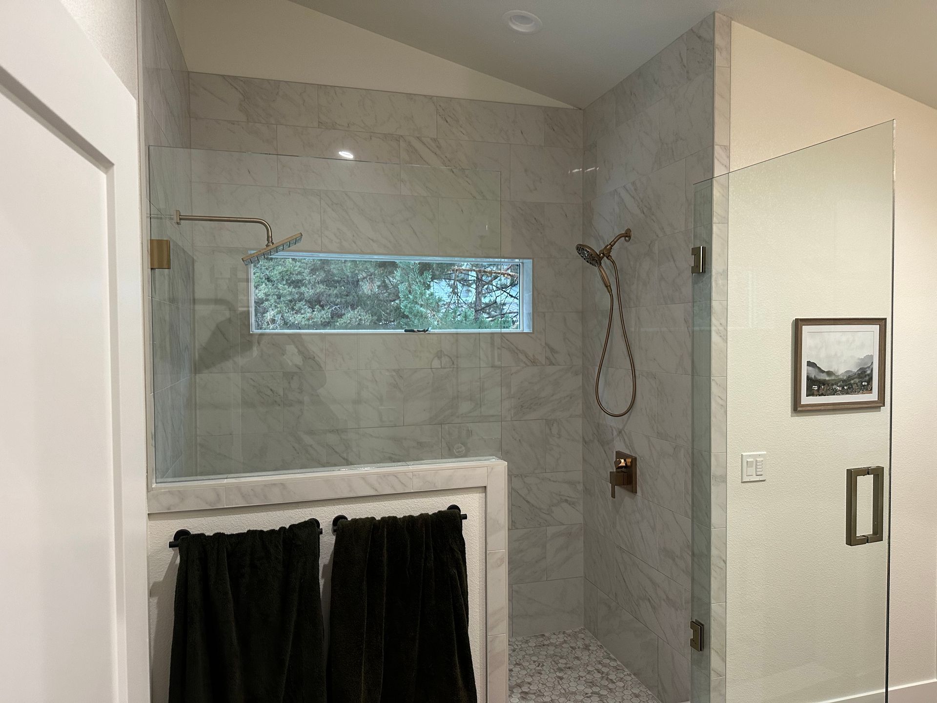 A bathroom with a walk in shower and a window