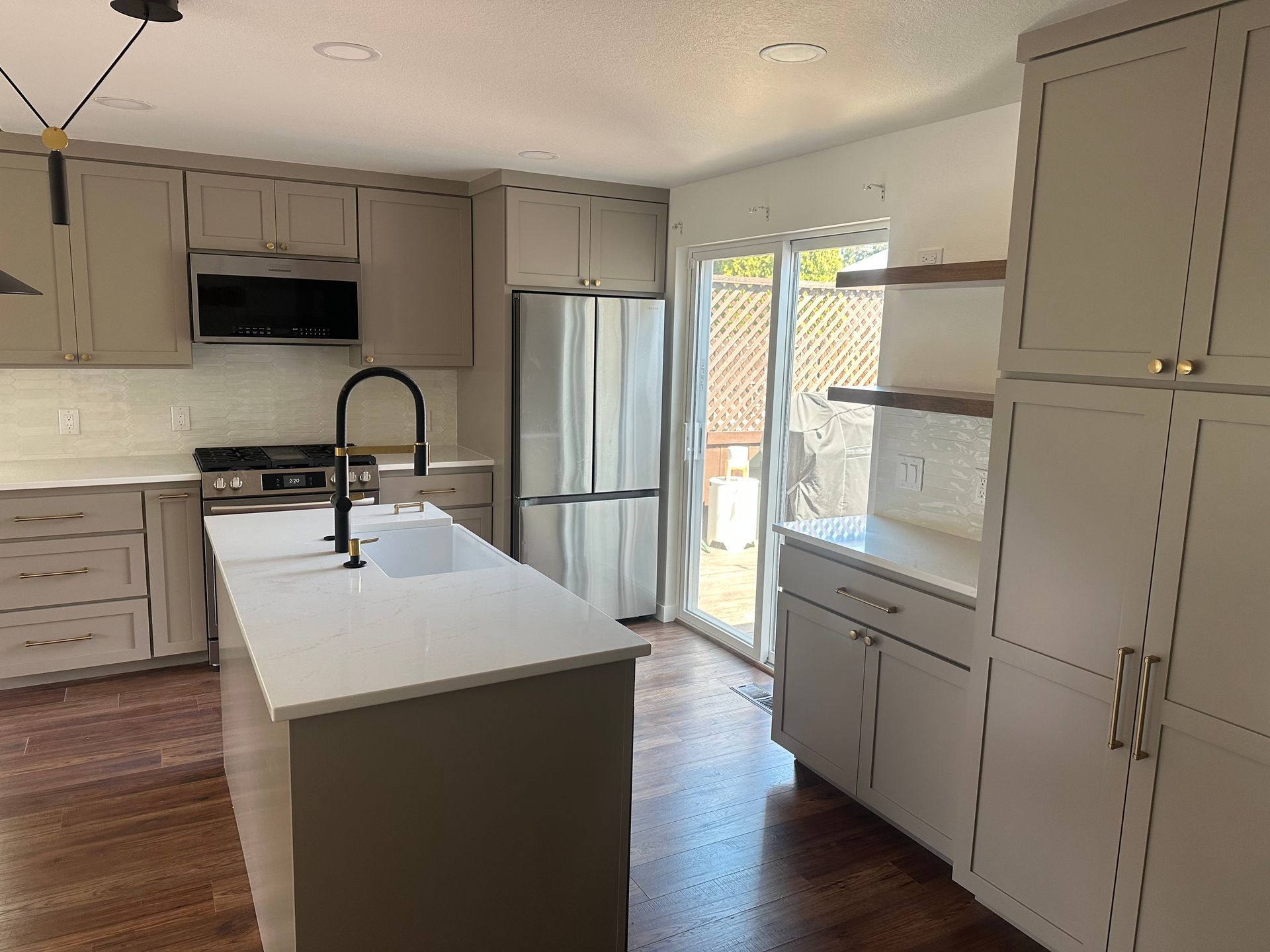 A kitchen with white cabinets , stainless steel appliances and a large island.