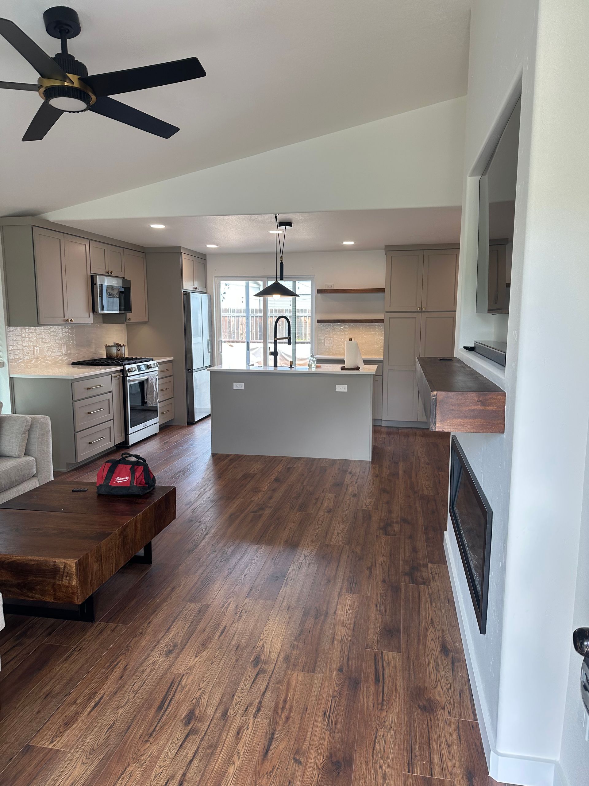 A living room with hardwood floors and a ceiling fan.